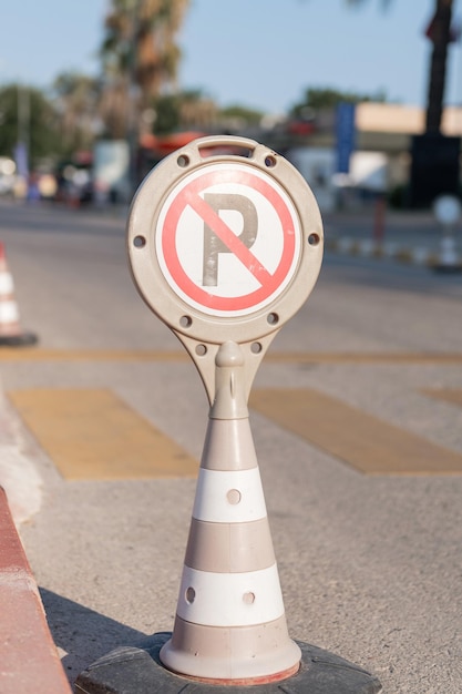 Kegelwaarschuwing over een parkeerverbod voor auto's en auto's. verkeersveiligheidsteken op de weg van de stadsstraat. gevaar waarschuwingssymbool op stedelijke manier voor auto's. besturen en regelen van het rijden in het stadspad