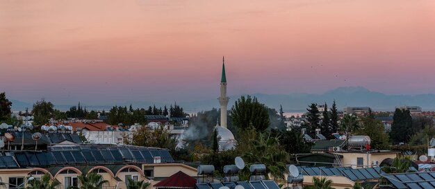 ケメル、トルコ-街の屋根と山に沈む夕日の夜景