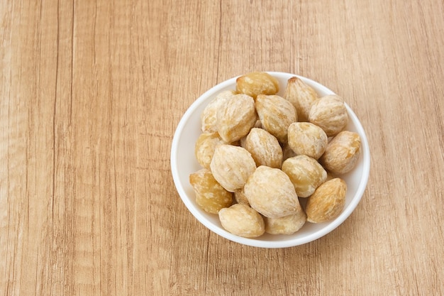 Kemiri or Candlenut Seeds on wooden background food ingredient