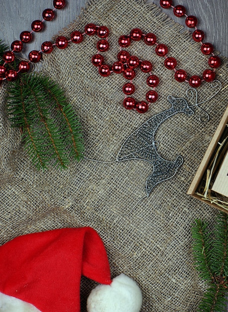 Kenmerken van kerstnieuwjaar in lay-out op grijze achtergrond. Vuren takken naast kralen en een hert.