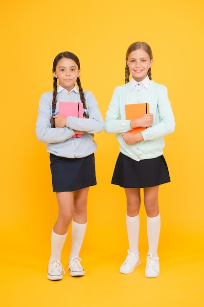 Kennis dag. Schooldag leuke vrolijke momenten. Kinderen schattige studenten. Schoolmeisjes beste vrienden uitstekende leerlingen. Middelbare school. Schoolmeisjes nette uitstraling schooluniform. Schoolvriendschap.