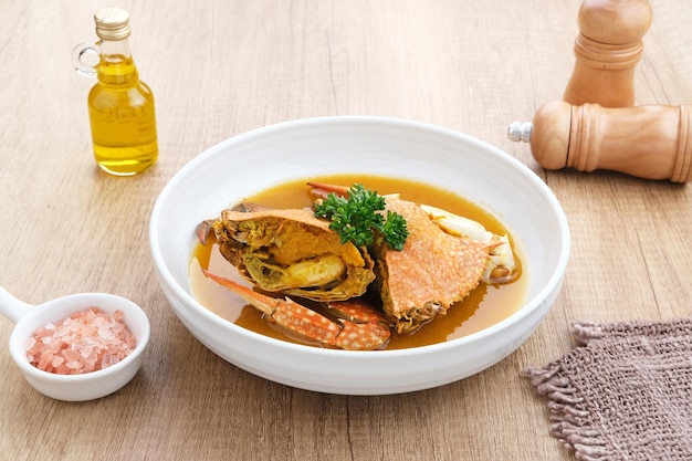 Kepiting Saus Padang (Crab with Padang Sauce), spicy and savory. Served in white bowl.