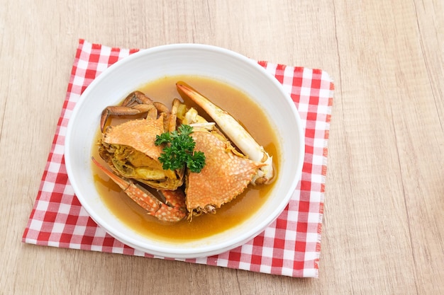 Kepiting Saus Padang (Crab with Padang Sauce), spicy and savory. Served in white bowl.