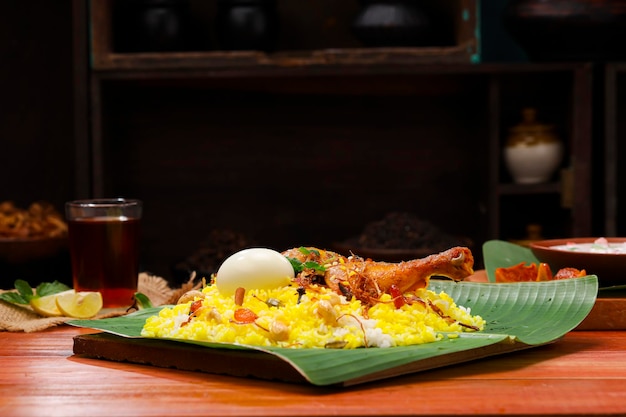 Kerala Chicken biryani traditioneel gerangschikt in een bananenblad en raita als bijgerecht