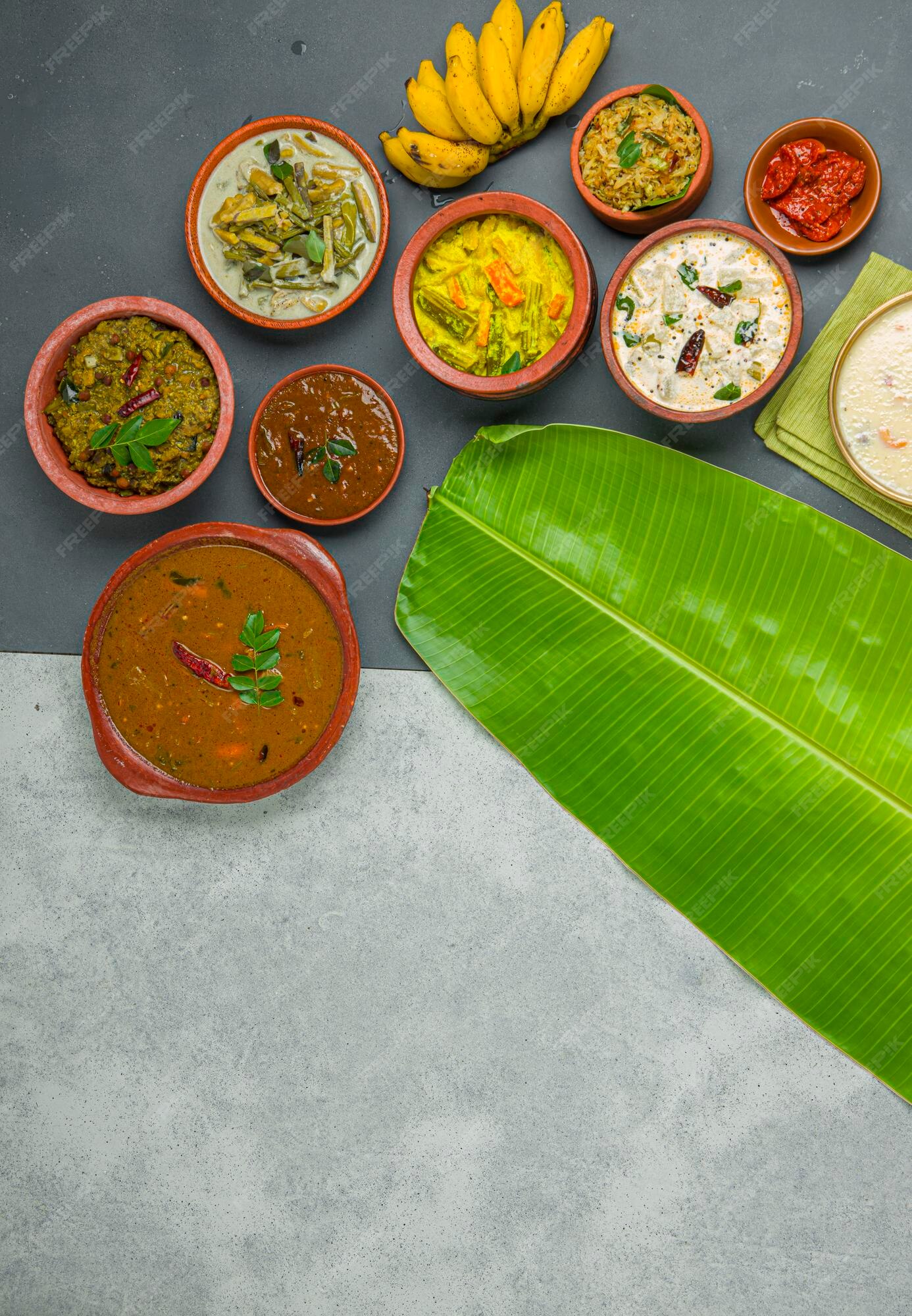 Premium Photo | Kerala traditional feast side dishes arranged in a two  color background with fresh banana leaf
