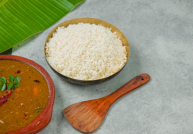 케랄라 전통 잔치 반찬과 밥은 음식을 제공하기 위해 바나나 잎과 함께 두 가지 색상 배경으로 배열됩니다.