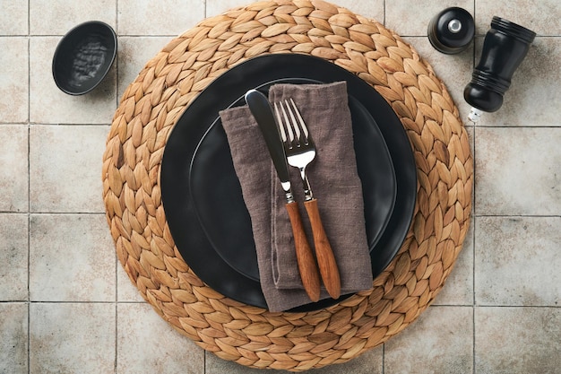 Keramische lege zwarte plaat zilverwerk en linnen keuken handdoek servet op oude keramische tegel tafel achtergrond koken stenen achtergrond bovenaanzicht met kopie ruimte plat leggen