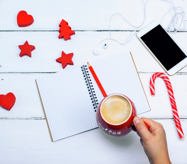 Keramische rode kop met zwarte koffie in een vrouwelijke hand