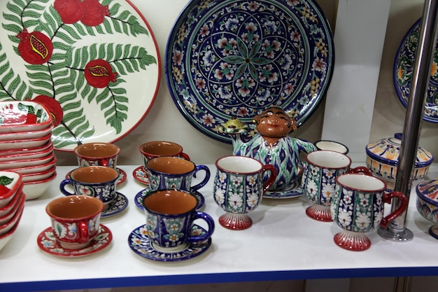 Keramische souvenirborden vazen theeserviezen in de schappen van een winkel in Samarkand in Oezbekistan 2904-2019