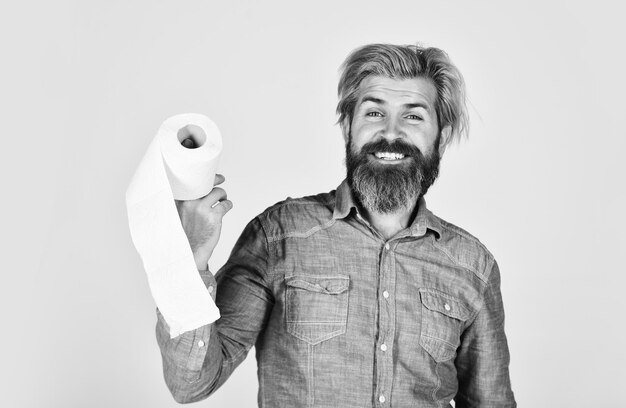 Kerel die plezier heeft met toiletpapier Zachtheid, sterkte en absorptievermogen Voorkom hamsteren van toiletpapier Man houdt toiletpapier vast Hipster met weefsellimiet Gebruik Online winkel Koop essentiële goederen