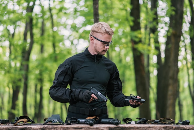 Kerel in het bos test zijn wapens voor schietsport.