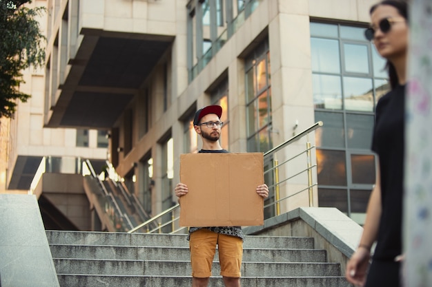 Kerel met bordje man staat te protesteren tegen dingen die hem irriteren