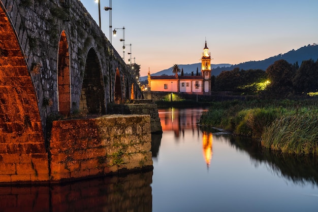 Kerk aan het einde van de Romeinse brug van Ponte de Lima, in Minho, Portugal. Blauw uur.