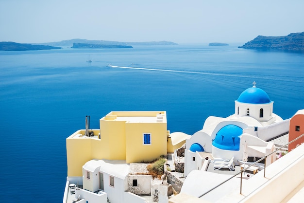 Kerk met blauwe koepels in Oia-stad, Santorini-eiland, Griekenland. Prachtig landschap met uitzicht op zee