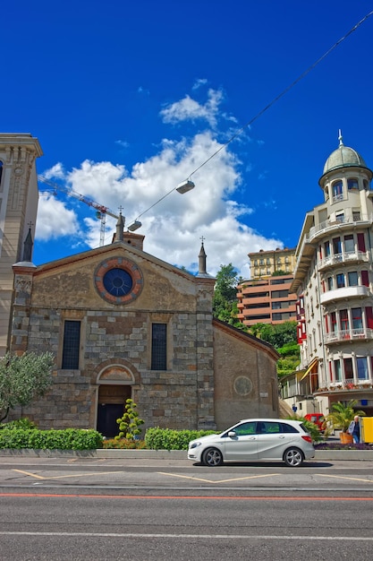 Kerk van Santa Maria degli Angioli aan de promenade van luxe resort Lugano, kanton Ticino in Zwitserland. Mensen op de achtergrond