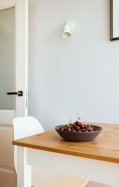 Kersenbessen op plaat op houten tafel in moderne keuken