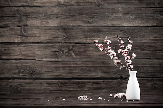 Kersenbloemen in vaas op donkere houten achtergrond