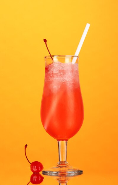 Kersencocktail met ijs op oranje achtergrond