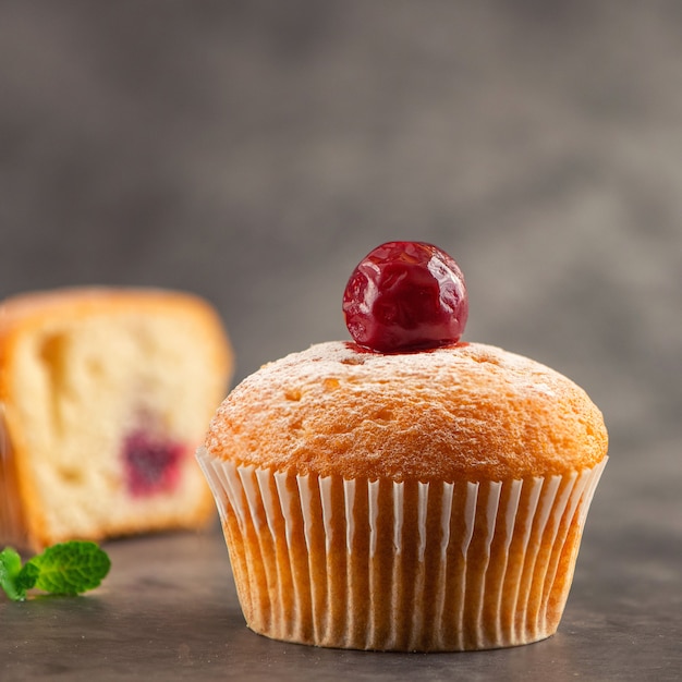 Kersenmuffin op donkere achtergrond. Zijaanzicht