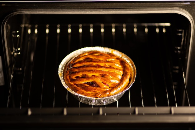 Kersentaart Kersentaart in de oven Verse taart uit de oven De gastvrouw bakte gebakjes in de oven