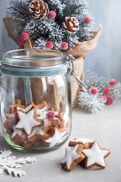 Kerst achtergrond in groen en blauw met smakelijke ster gember koekjes in een pot met versierde kerstboom