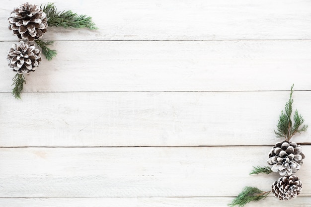 Kerst achtergrond. kerst frame gemaakt van sparren en dennenkegels decoratie rustieke elementen op een witte houten bord. creatieve platte lay, bovenaanzicht ontwerp