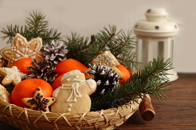 Kerst achtergrond Kerst peperkoek pijnboomtakken mandarijnen in decoratieve gerechten tegen een witte lantaarn lichte achtergrond ruimte voor tekst