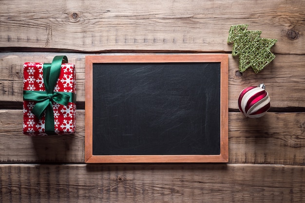 Kerst achtergrond. Leisteen bord en kerstboom speelgoed op een houten tafel