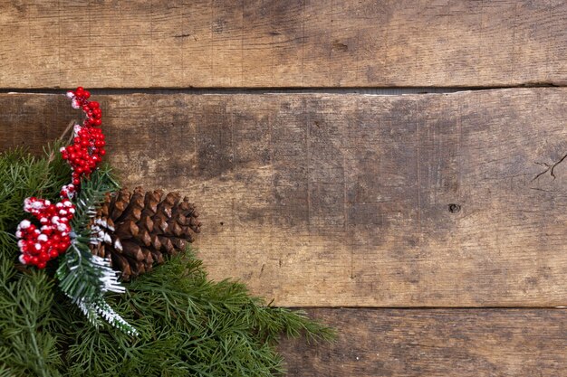 Kerst achtergrond met dennenboom en dennenkegel op donker houten bord Kopieer ruimte voor tekst