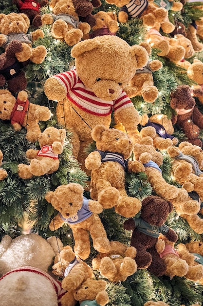 Foto kerst achtergrond met geschenkkistjes onder de kerstboom en teddybeer decoratie