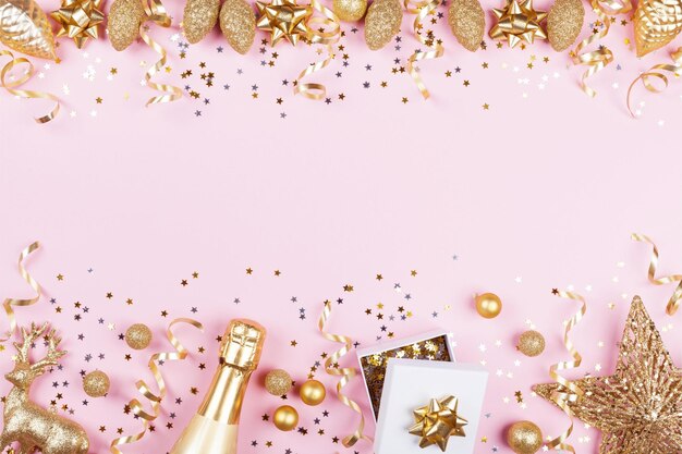 Kerst achtergrond met gouden geschenk of cadeau doos champagne en vakantie versieringen op roze verleden