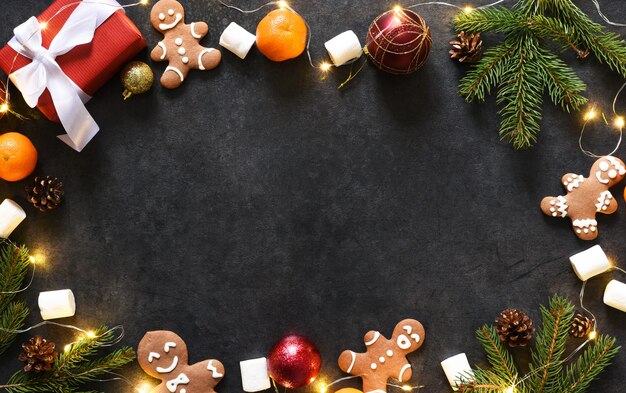 Kerst achtergrond met peperkoek koekjes en geschenken. New Year's lay-out op een zwarte achtergrond.