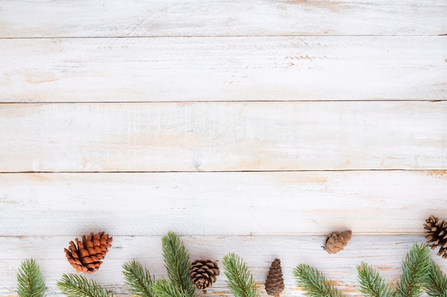 Kerst achtergrond - sparren en dennenkegels decoratie elementen rustiek op witte houten tafel. Creatieve flat layout en bovenaanzicht compositie met ruimte en kopie ruimte ontwerp.