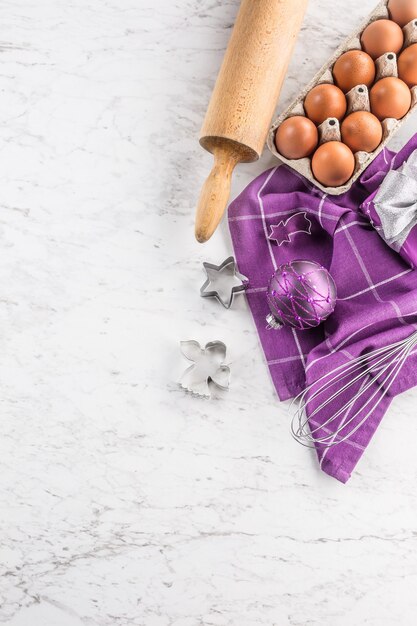 Kerst bakken paarse geschenken decoraties eieren en keukengerei op marmeren tafel.