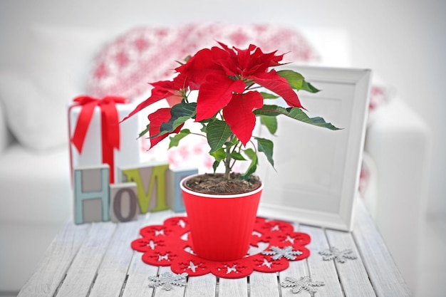 Kerst bloem poinsettia en decoraties op tafel met kerstversiering, op lichte achtergrond