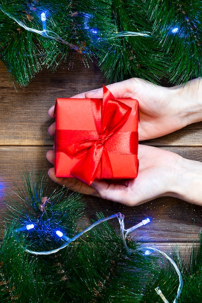 Kerst cadeau vak in vrouwelijke handen op een houten tafel