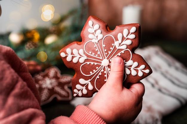 Kerst compositie. een kerstboom versierd met speelgoed en een slinger en peperkoeken. peperkoek in de handen van een kind. hoge kwaliteit foto