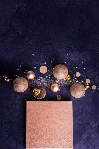 Kerst compositie. Kerstcadeau concept met gouden versieringen, ballen, glitters op een donkerblauwe achtergrond. Ruimte kopiëren Minimalisme plat leggen