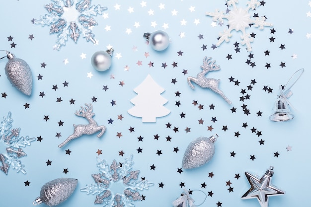 Kerst compositie. Zilveren decoratie op pastelblauwe achtergrond. Kerstmis, winter, nieuwjaarsconcept. Plat leggen, bovenaanzicht, ruimte kopiëren - Afbeelding