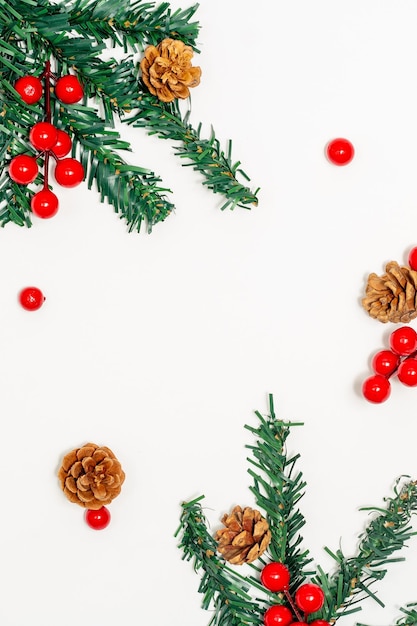 Kerst concept Fir tree takken versieren met dennenappels en rode bessen op witte achtergrond