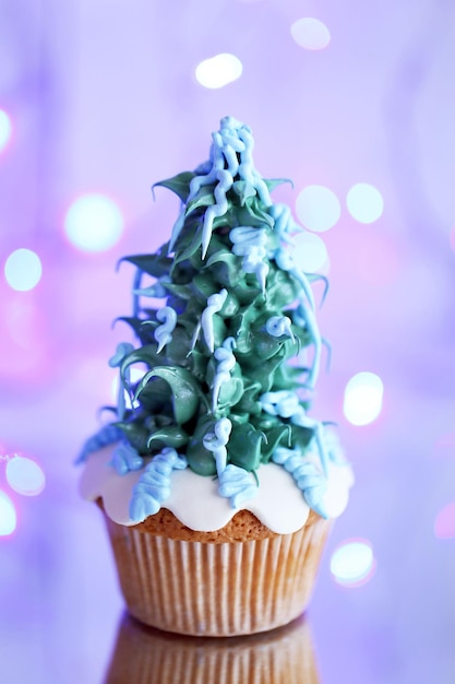 Kerst cupcake met lampjes op de achtergrond