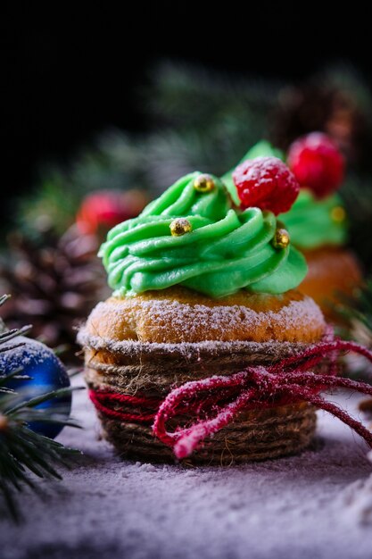 Kerst cupcakes in een feestelijk en besneeuwd bos. Dessert voor Nieuwjaar en kerstviering.