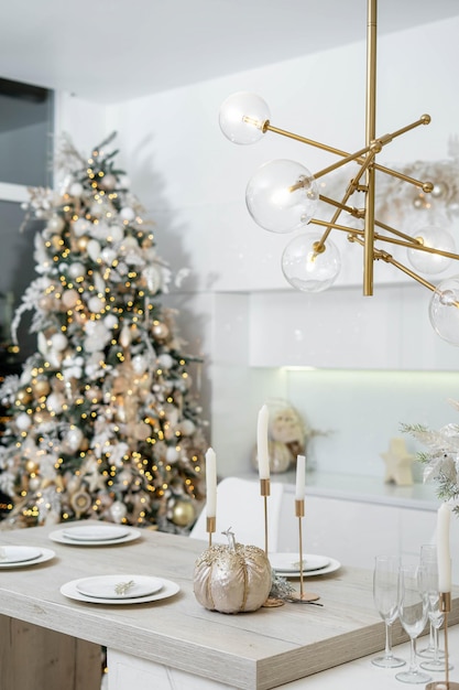 Kerst decor. Licht interieur van witte keuken met versierde kerstboom, slingers