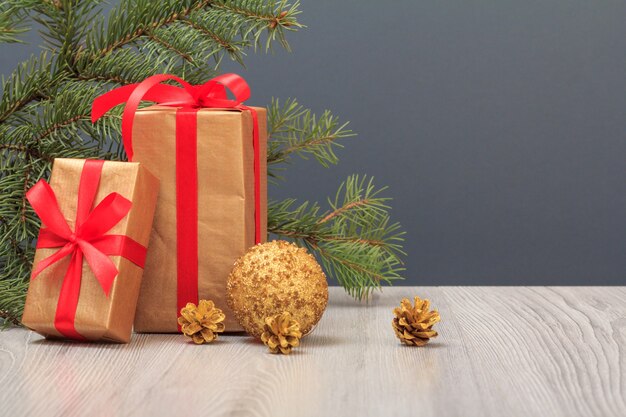 Kerst decoratie. Geschenkdozen, speelgoedbal, kegels en natuurlijke sparrentak op grijze achtergrond. Kerst wenskaart concept.