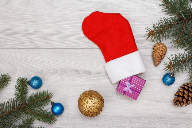 Kerst decoratie. Santa's laars, geschenkdoos, dennentakken met kegels en kerstspeelgoed op grijze houten planken. Bovenaanzicht. Kerst wenskaart concept.