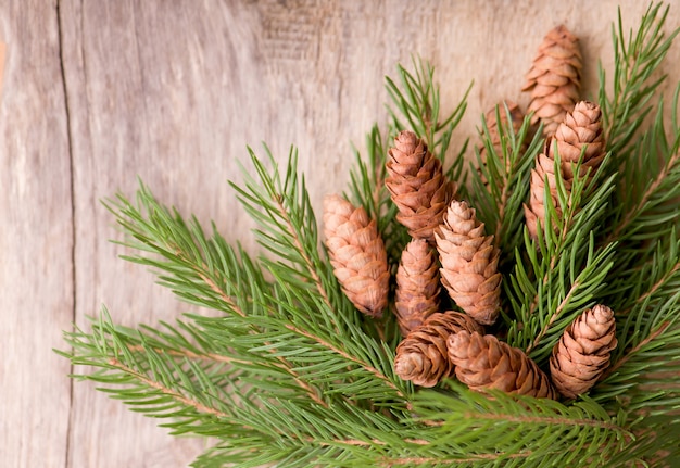 Foto kerst decoratieve rustieke frame met vuren twijgen en kegels op donkere houten achtergrond, copyspace voor uw tekst