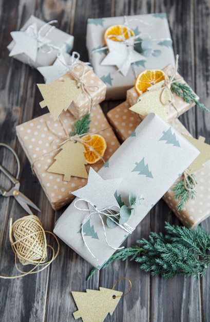 Kerst decoratieve zelfgemaakte geschenkdozen verpakt in bruin kraftpapier op een donkergrijze houten ondergrond