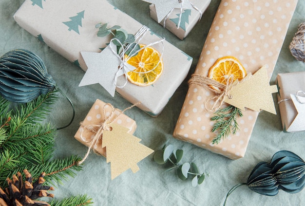 Kerst decoratieve zelfgemaakte geschenkdozen verpakt in bruin kraftpapier op een groene textielachtergrond