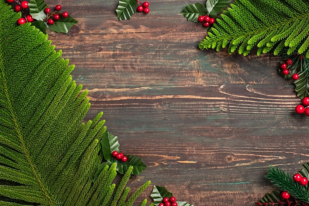 Kerst dennenblad en maretak op houten tafel, rood