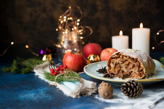 Kerst en Nieuwjaar dessert. Apfelstrudel met vakantielichten.